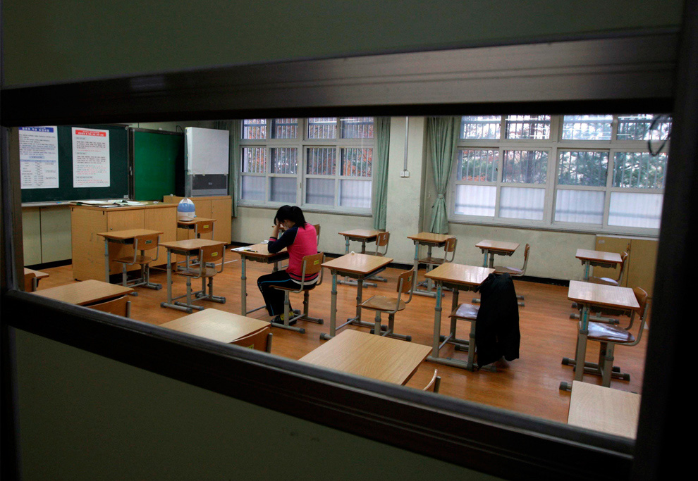 Южнокорейская студентка, страдающая от высокой температуры, находится на экзамене в отдельной комнате в качестве меры предосторожности против вируса H1N1. Она ждет, чтобы сдать вступительные экзамены в колледж в Deajeon, к югу от Сеула, Южная Корея, 12 ноябрь 2009 г. (AP Photo/Yonhap, Yang Yong-suk)