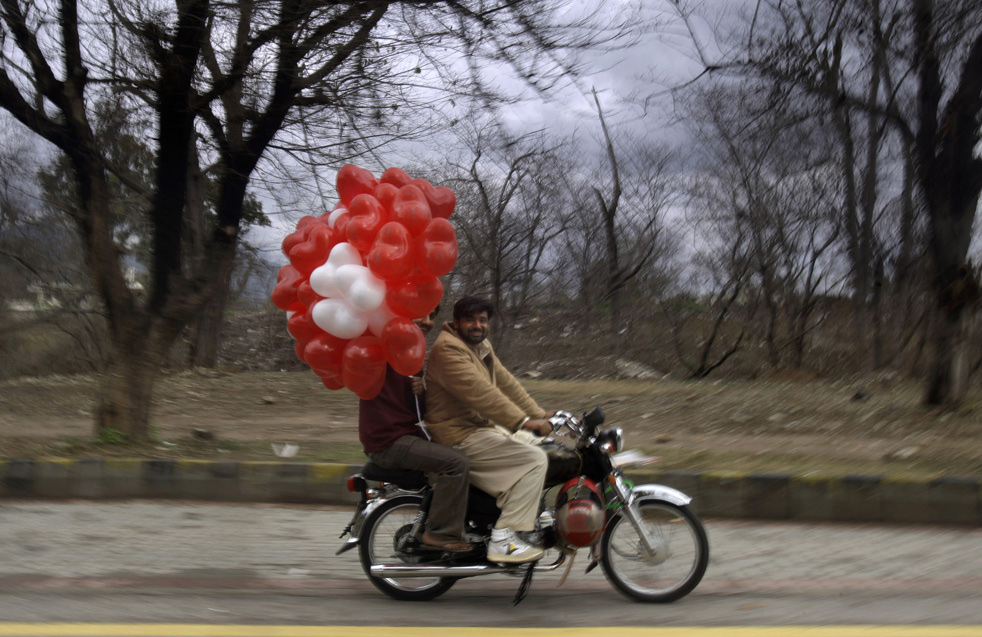 Мужчины едут на мотоцикле с воздушными шариками.