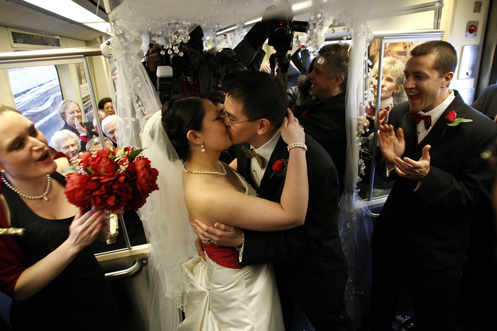 Молодожёны целуются в трамвае.