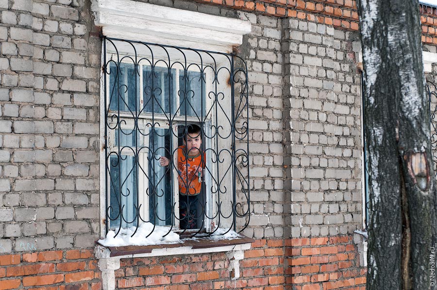 Мальчик выглядывает из окна центра "Колыбель".