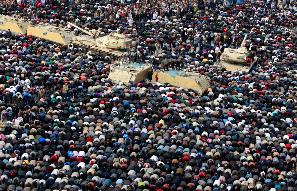 Египтяне молятся на площади рядом с танками.