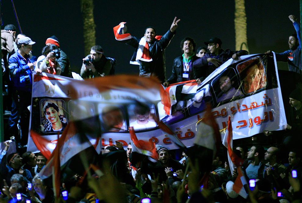 Люди улыбаются и машут флагами Египта.