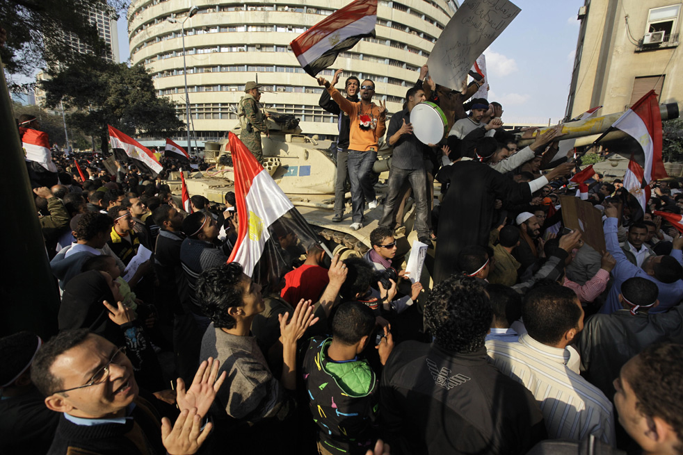 Протестующие забрались на танк, стоящий напротив штаб-квартиры государственного телеканала Египта в Каире, 11 февраля 2011 года. Незадолго до этого президент Хосни Мубарак объявил о том, что уходит в отставку и передаёт власть в руки военных. (AP / Ben Curtis)