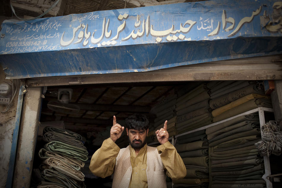 Пакистанец стоит возле магазина