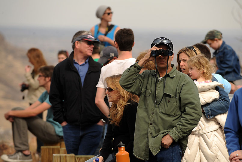 Onlookers watch and take photos of the Indian Gulch Fire
