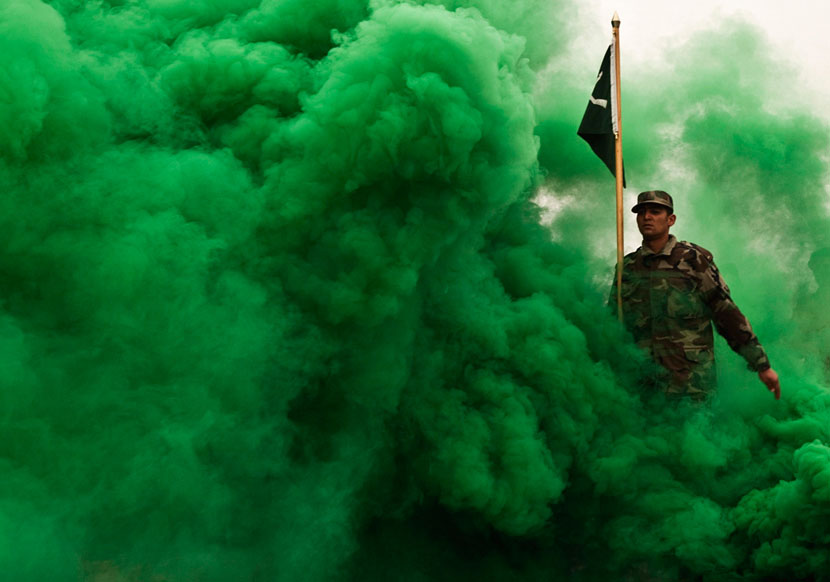 Афганский новобранец марширует сквозь зелёный дым.
