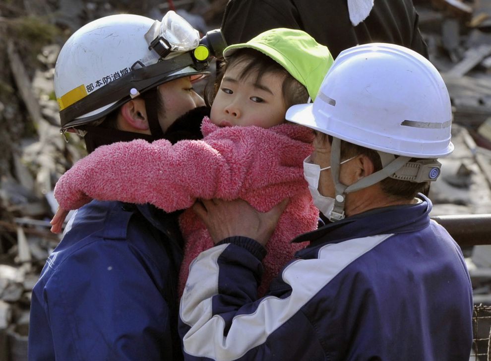 Спасатели держат ребёнка.