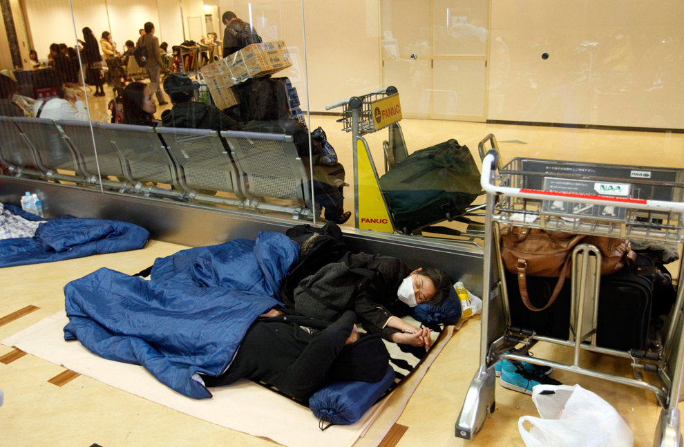 Пассажиры спят в аэропорту на полу.