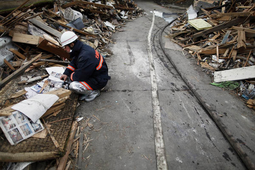 Пожарный осматривает руины в Японии