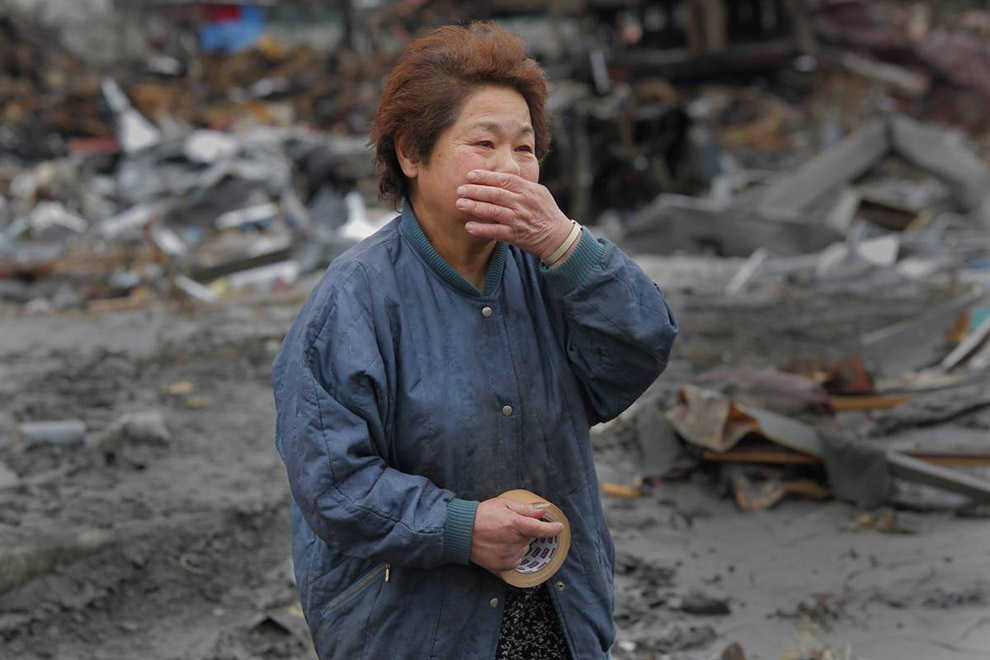 Женщина ищет племянника после цунами в Японии