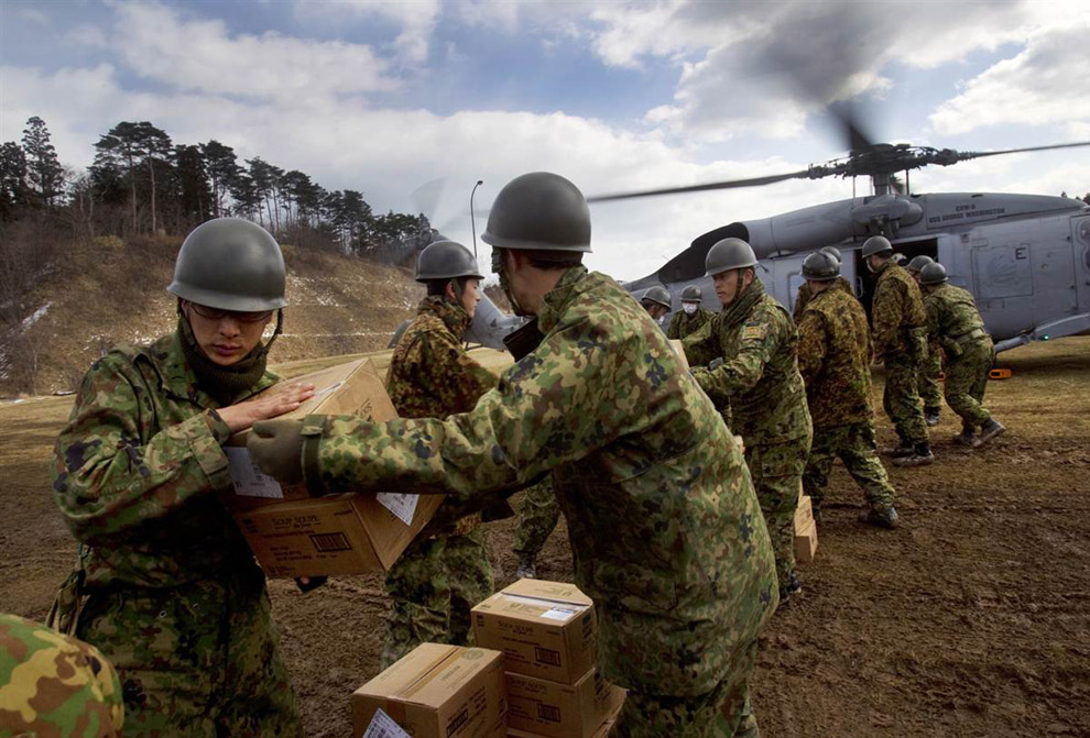 Солдаты разгружают коробки с продуктами питания 