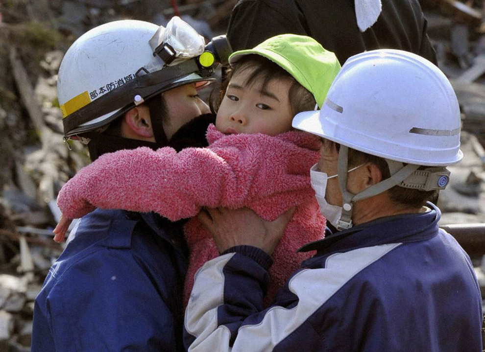 Спасатели держат на руках девочку