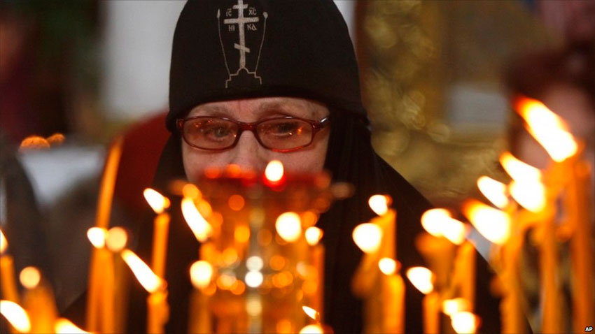 Монахиня зажигает свечи