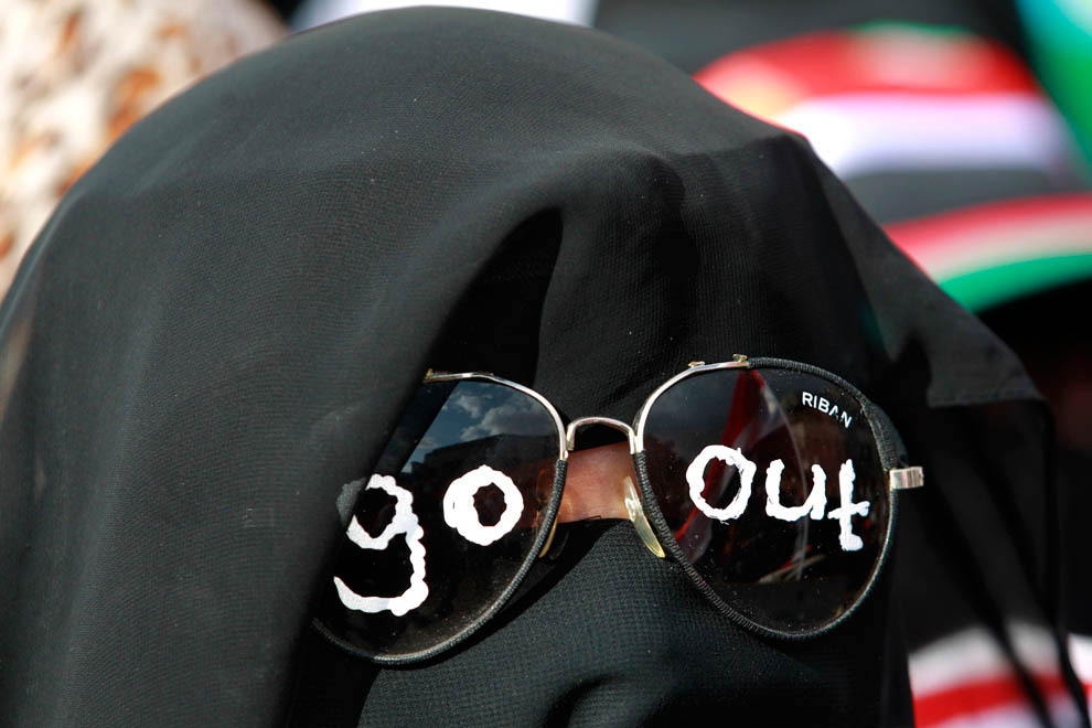Женщина с расписанными солнечными очками принимает участие в демонстрации