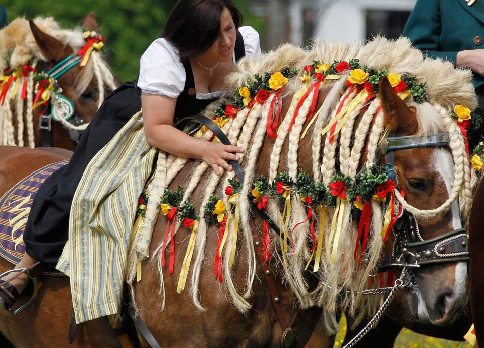 Местная женщина едет верхом на украшенной лошади, чтобы просить благословение для людей и животных в церкви Св. Георгия, расположенной недалеко от Траунштайна, в южной Германии.