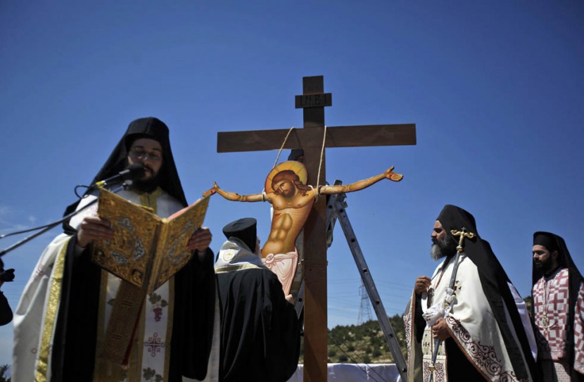Греческий православный священник держит икону Иисуса