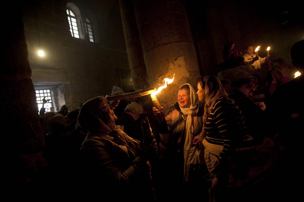 Христианские паломники зажигают свечи и освещают территорию