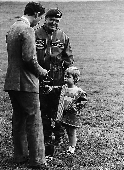 Принц Уильям и принц Чарльз стоят возле парашютиста