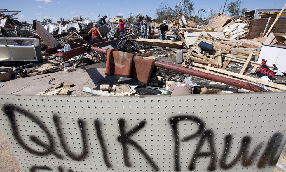 Работники ищут оружие в развалинах ломбарда. (AP Photo/Dave Martin) 