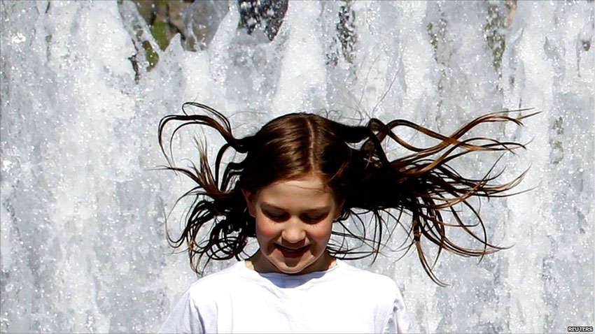 девочка играет в фонтане
