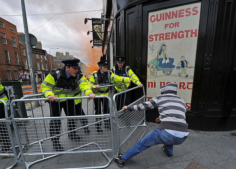 Протестующий пытается убрать ограду