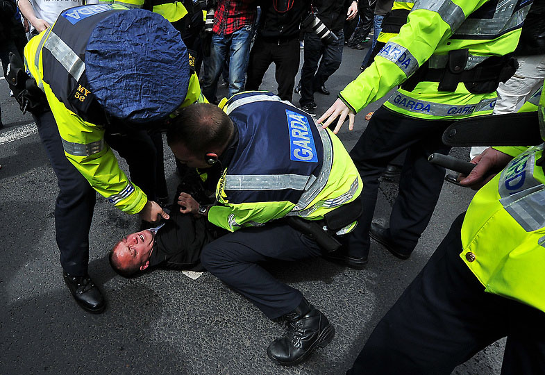 Полицейский задерживает одного из протестующих