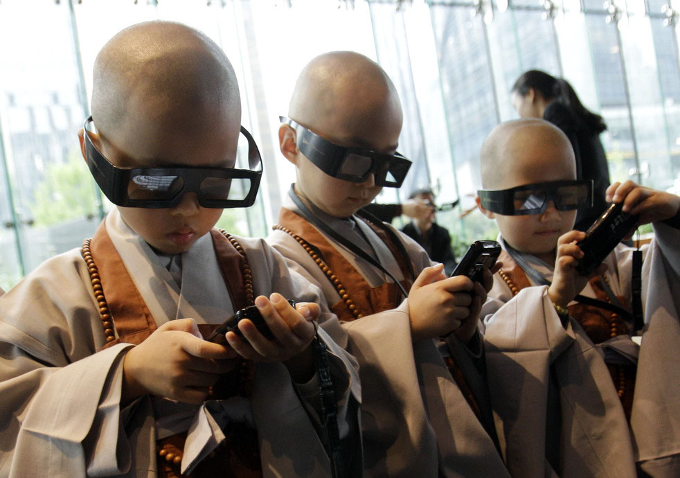 Наголо бритые мальчики в 3-D очках со смартфонами