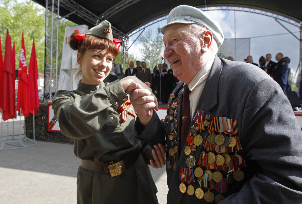 Женщина, одетая в военную форму Красной армии, и ветеран