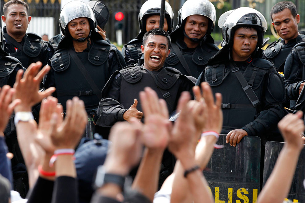 Полицейский показывает большой палец демонстрантам