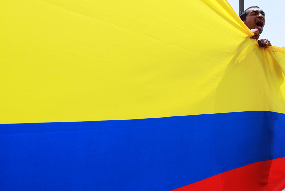 протестующие держат колумбийский флаг