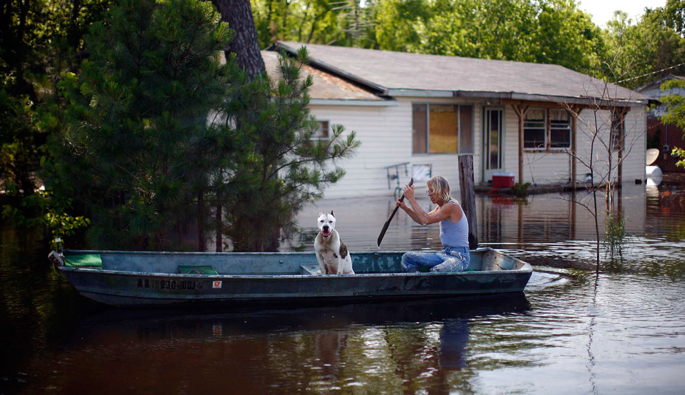 Роберт Сандерс сидит со своим псом Лаки в лодке