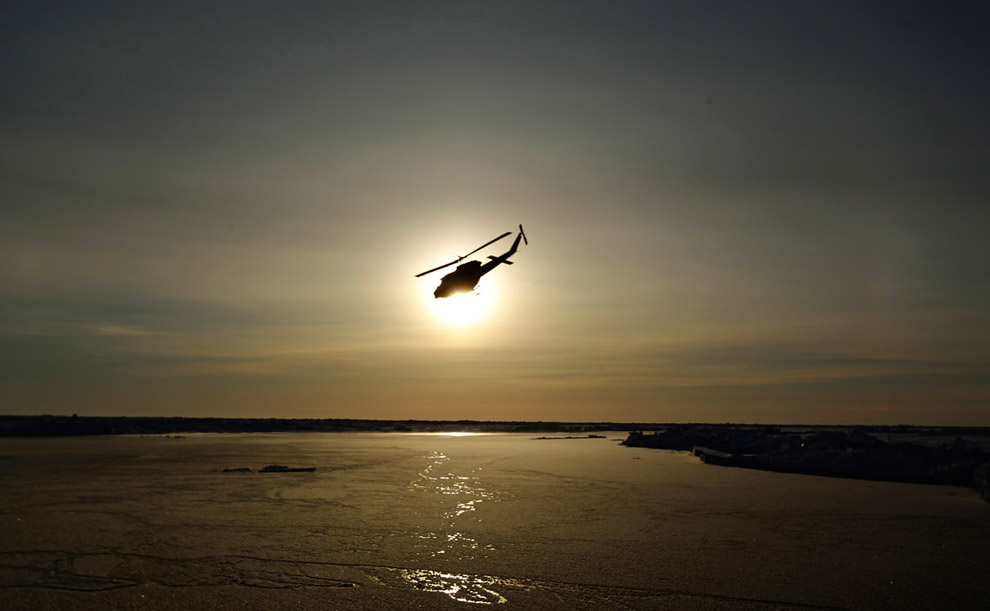 Вертолет летит над арктическими льдами 