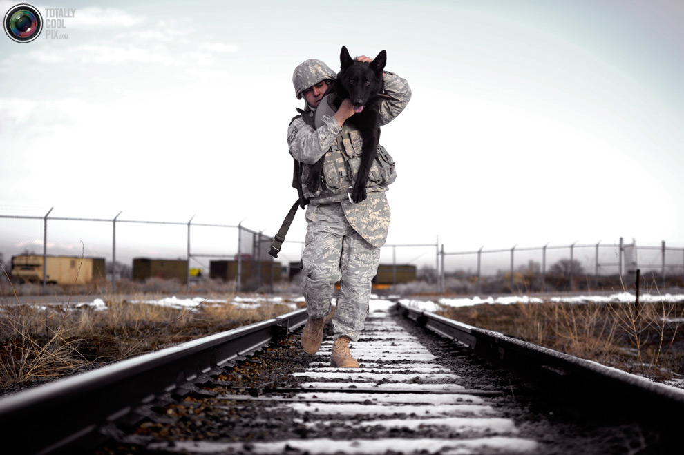 солдат несет собаку на плече