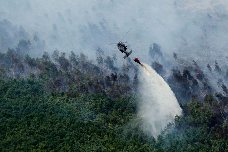 Вертолет выливает воду на пожар