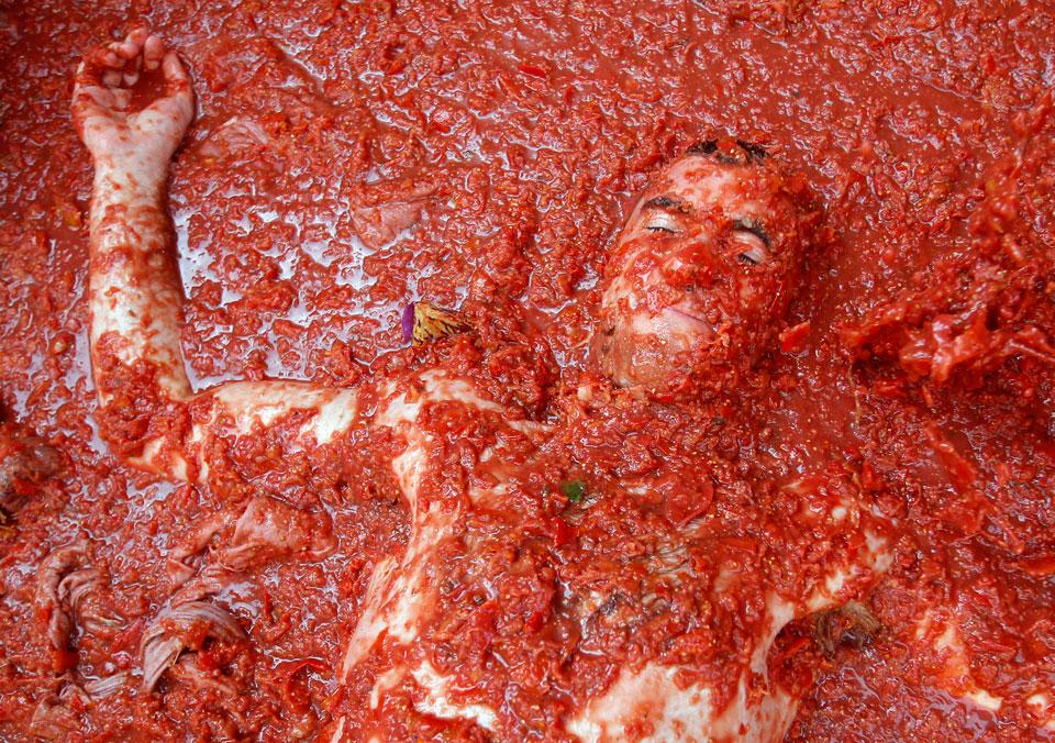 Участник ежегодной Томатины лежит в томатной массе