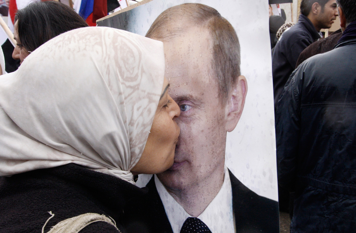 Жительница Сирии целует портрет Путина