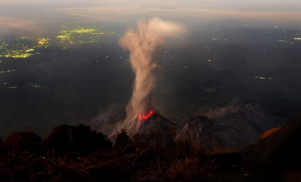 Фотограф Эндрю Холл (Andrew Hall) сделал этот потрясающий снимок извержения Сантьягито, активного купола вулкана Санта-Мария, в Гватемале 11 марта 2012 года. Город Реталулеу (на заднем плане) только начинает просыпаться. (© Andrew Hall)