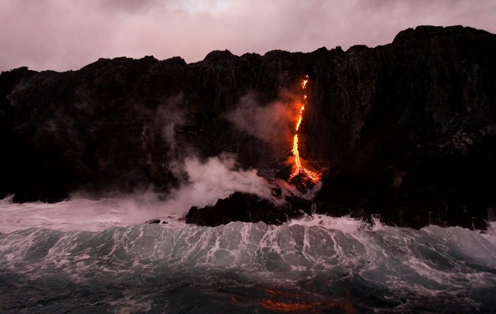 Лава стекает в океан в национальном парке Гавайские вулканы в Калапане, Гавайи, 27 ноября 2012 года. 