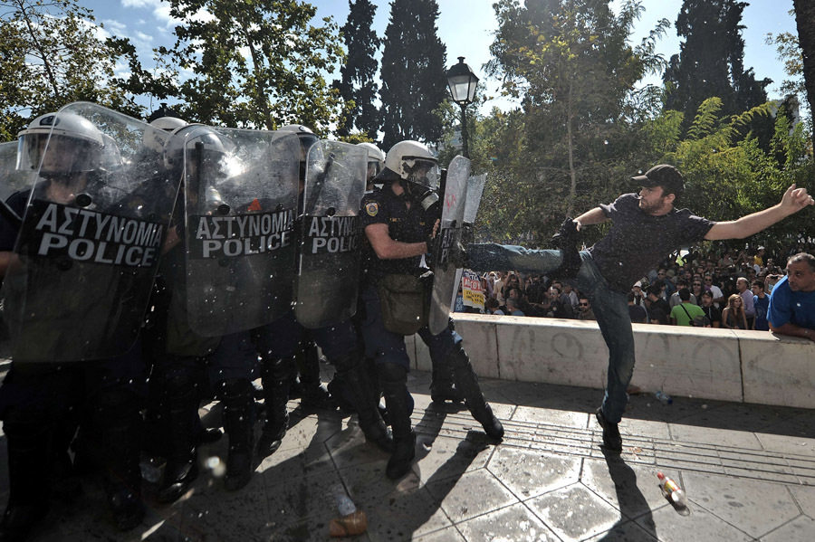 Демонстрант дерется с полицейскими в Афинах, Греция, 18 октября 2012 года.