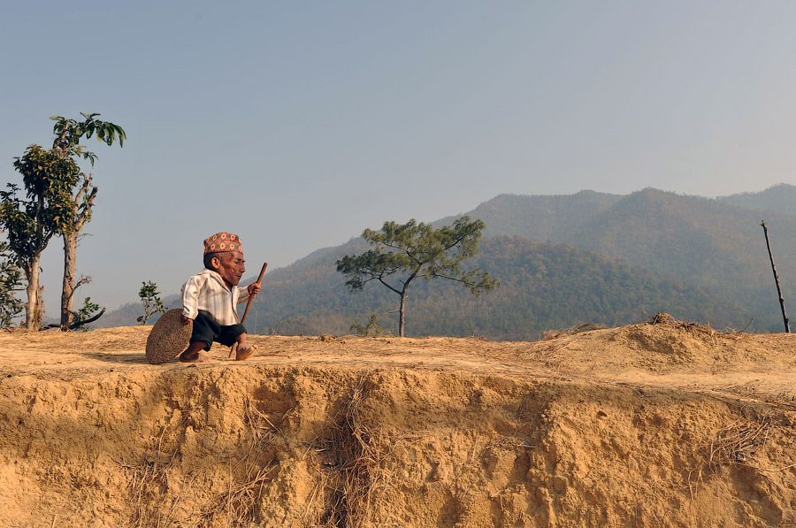 72-летний житель деревни Reemkholi Чандра Бахадур Данжи, рост которого составляет 56 см, прогуливается недалеко от своего дома, Непал, 21 февраля, 2012 года.