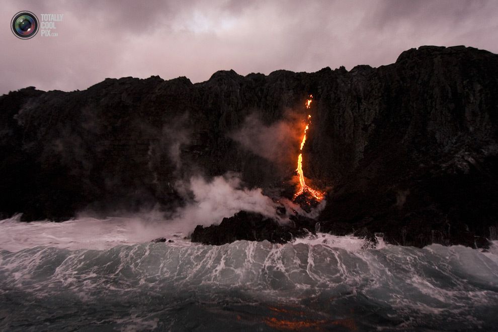 Лава стекает в океан в национальном парке Гавайские вулканы, Гавайи, США. 