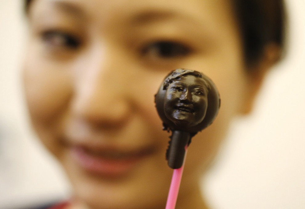Женщина показывает сладость из шоколада в форме её лица, изготовленную при помощи технологии 3D-сканирования, в Токио, 9 февраля 2013 года. 