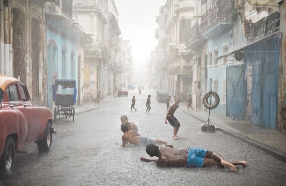В июле и августе в Гаване, Куба, стоит очень жаркая погода. Местные жители, особенно дети, всегда рады непродолжительным ливням, которые идут здесь довольно часто. (© Val Proudkii, USA, 2013 Sony World Photography Awards)