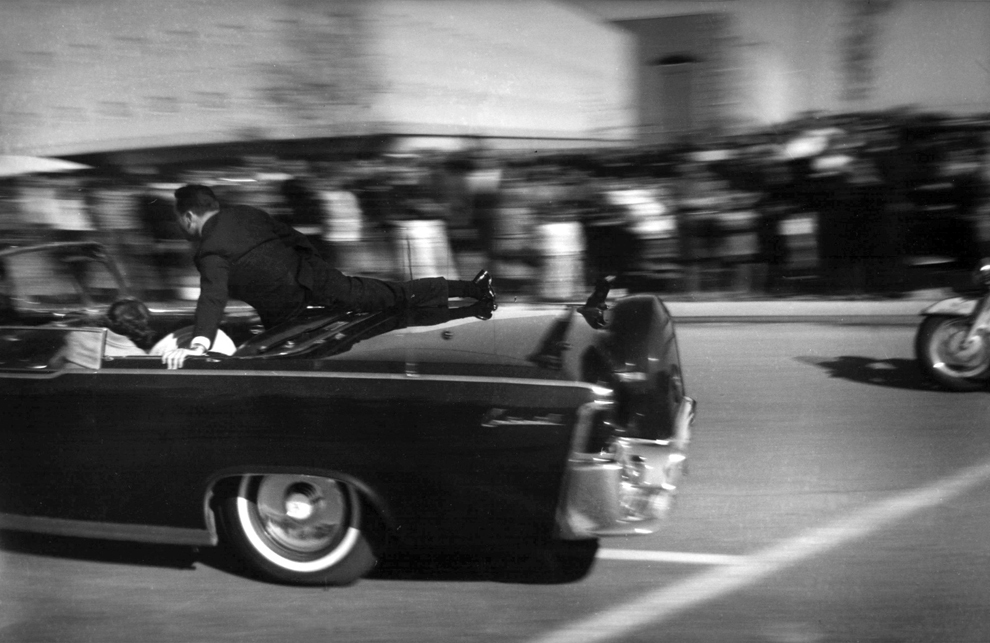 Лимузин со смертельно раненным президентом Джоном Кеннеди мчится в больницу в Далласе. (Justin Newman/Associated Press)