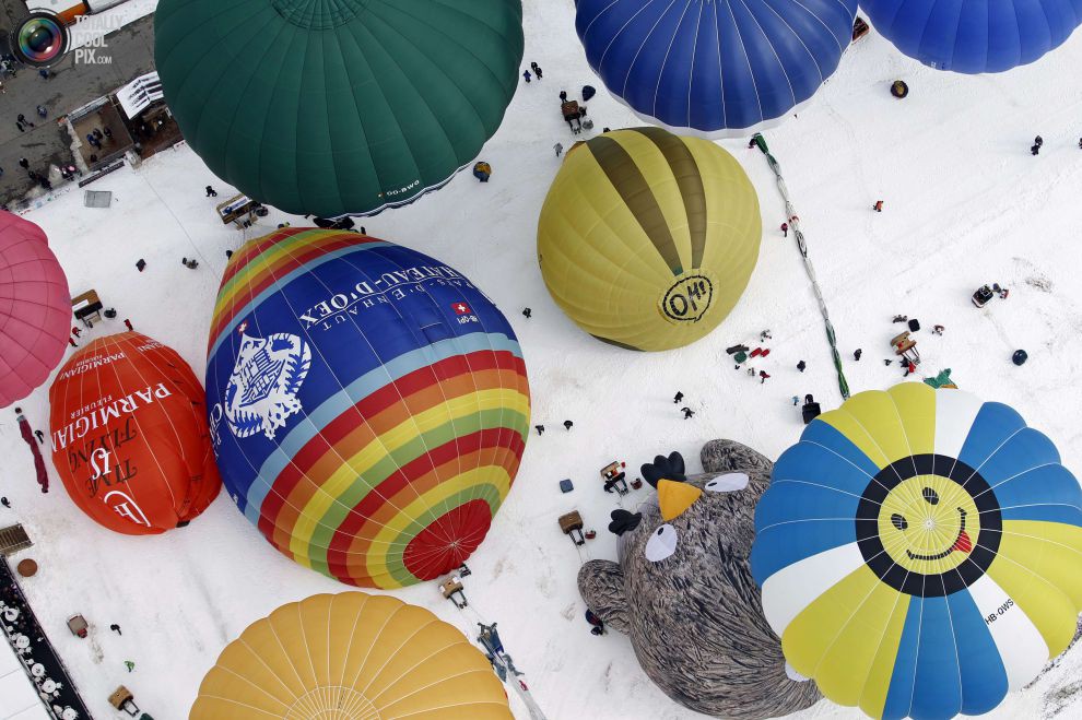 Воздушные шары всех форм и размеров готовятся к взлёту на 37-й Международной неделе воздухоплавания в Шато-д'О, Швейцария.