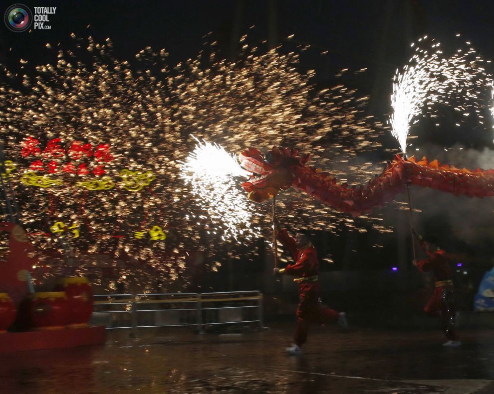 Артисты исполняют танец огненного дракона во время празднования Китайского Нового года в парке развлечений Happy Valley в Пекине.