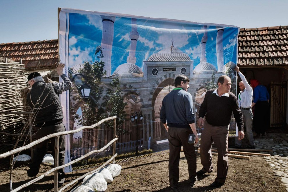 Люди устанавливают стенд на фестивеле культуры близ Шали, апрель 2015 года.