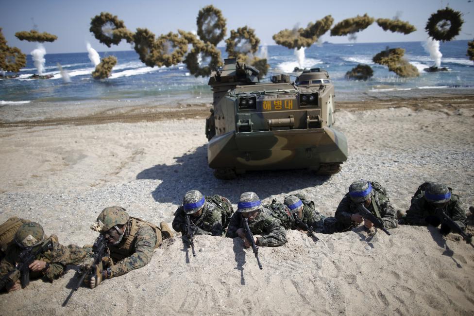 Морские пехотинцы вооруженных сил Южной Кореи (с синими лентами) и США занимают позиции во время совместных учений в Пхохане, Южная Корея, 12 марта 2016 года.