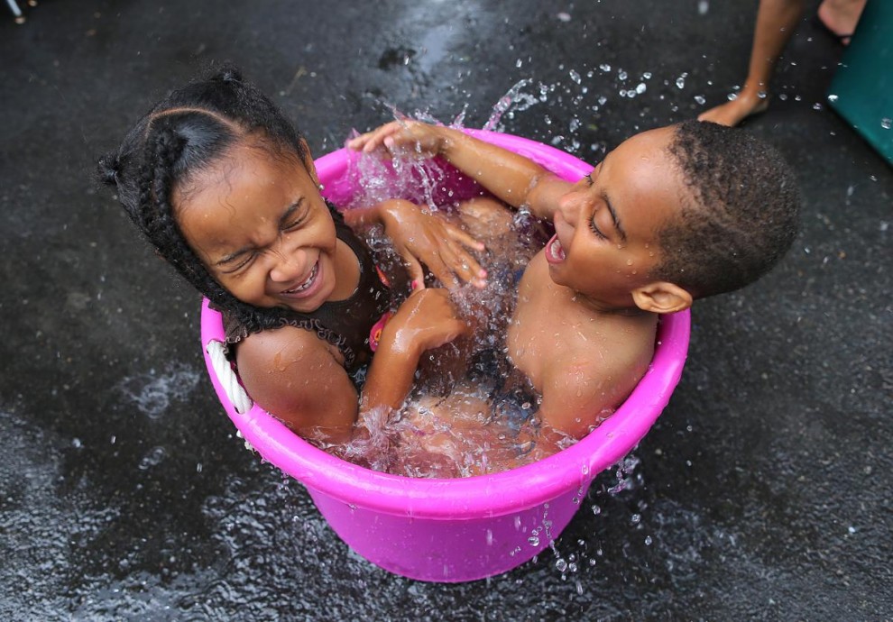 Дети купаются в ведре с водой