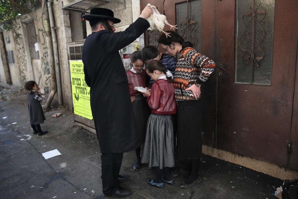 Ультраортодоксальный еврей совершает обряд капарот накануне Йом-Кипурa в квартале Меа Шеарим в Иерусалиме, Израиль.